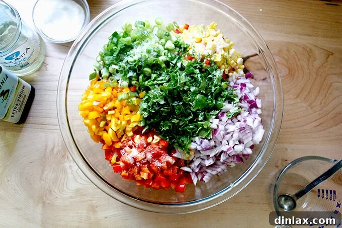 The bowl of Texas Caviar ingredients, now with olive oil, vinegar, salt, and fresh lime juice added, ready for a final toss.