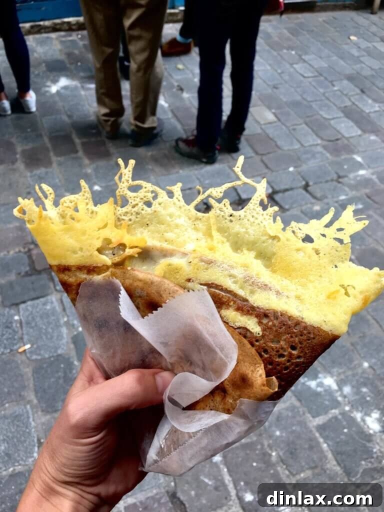 A perfectly cooked ham and cheese crêpe on a plate, ready to be enjoyed.