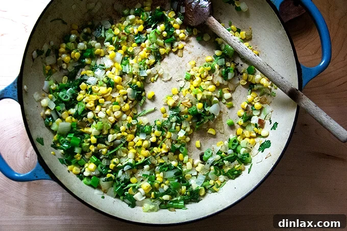 A medley of vibrant vegetables, including sautéed onions, sweet corn, fresh scallions, and herbs, cooking in a skillet, filling the air with delicious aromas.