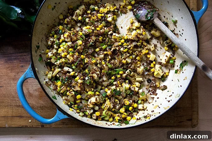 The vibrant quinoa and vegetable mixture in a skillet, seasoned with spices like smoked paprika, ready to be stuffed into the poblano peppers.