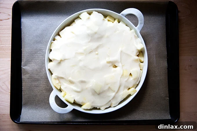Golden Sugar-Crusted Apple Cobbler 6 Apple cobbler nestled in a tart pan, placed on a sheet pan and ready to be baked in the oven.