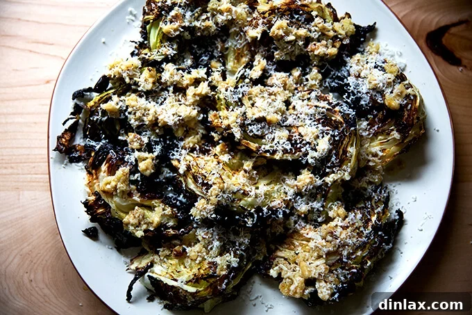 A vibrant platter showcasing roasted cabbage wedges elegantly topped with a generous amount of walnut salsa and a sprinkle of fresh Parmesan, ready to be enjoyed.