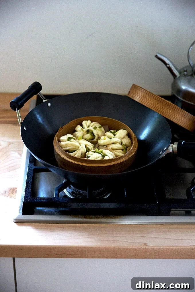 Chinese Steamed Scallion Twists 15 A wok with a bamboo steamer basket fitted inside, boiling water for steaming the buns.