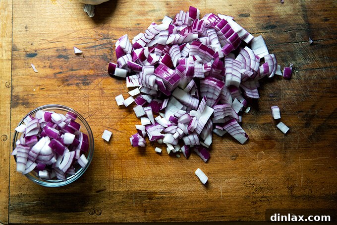 Hearty Black Bean Soup 5 A close-up shot of perfectly diced red onion on a chopping board, ready for cooking and garnishing the black bean soup.