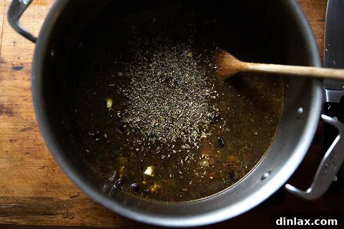 Hearty Black Bean Soup 10 A pot filled with all the ingredients for black bean soup, including beans, liquid, and spices, beginning to simmer on the stovetop.