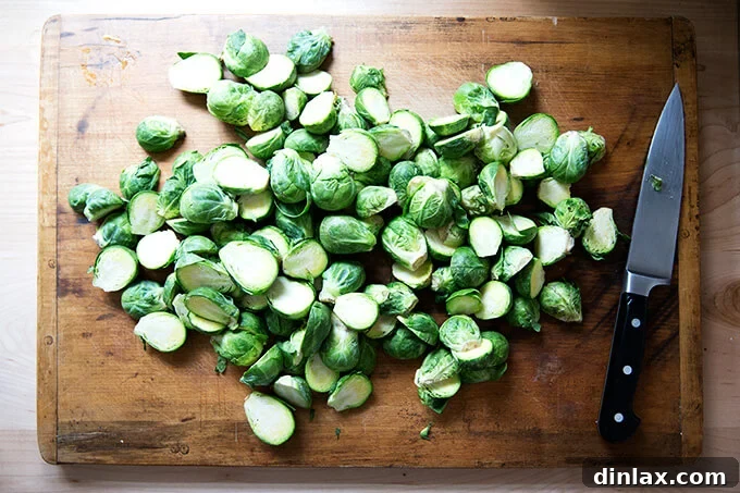 A board with perfectly halved Brussels sprouts, ready for seasoning.