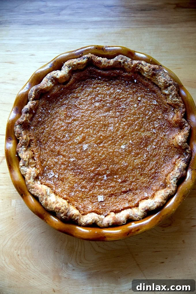Sister Pie's Irresistible Salted Maple Pie 15 A stunning close-up of a perfectly baked salted maple pie, cooled and ready for slicing, showing off its smooth, inviting surface.