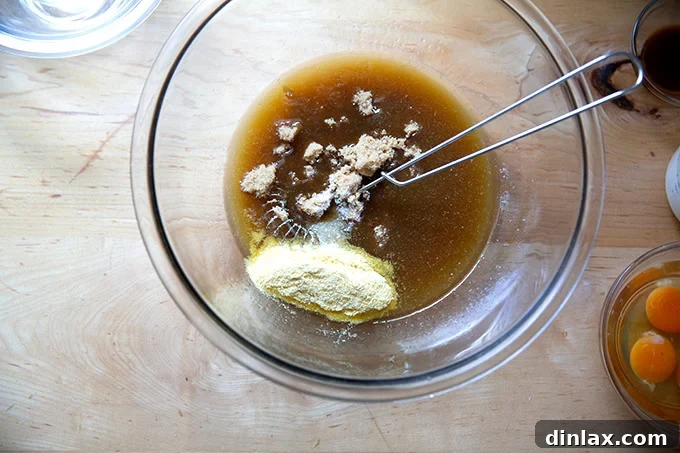 Sister Pie's Irresistible Salted Maple Pie 6 A bowl showing a mixture of maple syrup and melted butter, with brown sugar, cornmeal, and salt freshly added on top, before whisking.