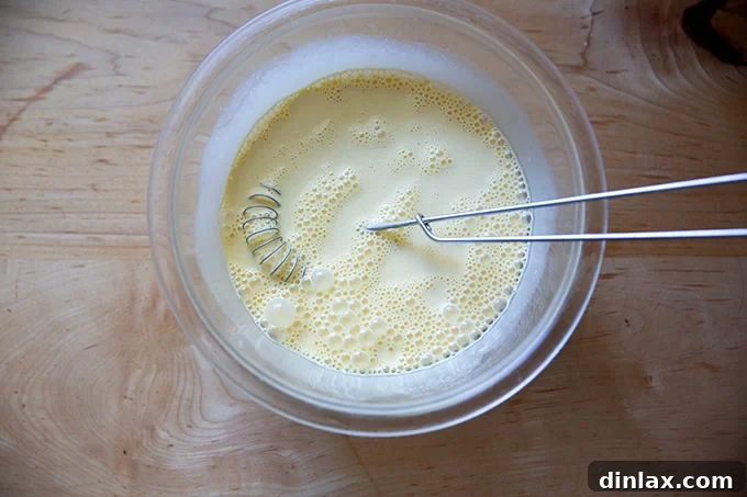 Sister Pie's Irresistible Salted Maple Pie 9 A bowl with heavy cream, vanilla extract, and eggs, now thoroughly whisked together into a smooth, pale yellow liquid, ready for the next step.