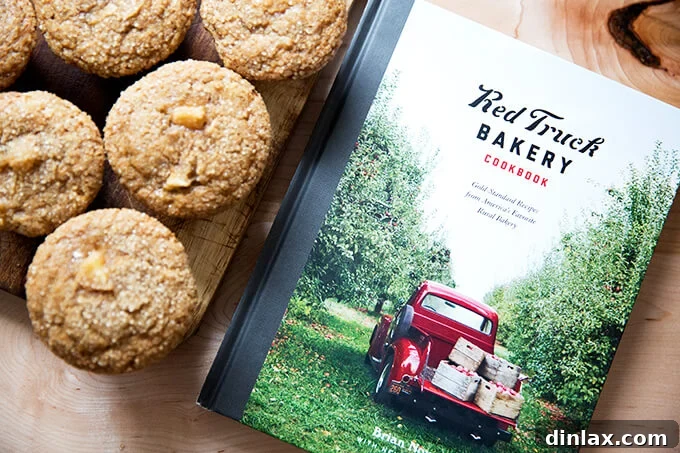 Harvest Apple Muffins 11 The Red Truck Bakery cookbook displayed alongside a batch of baked Apple Orchard Muffins, ready to be enjoyed.
