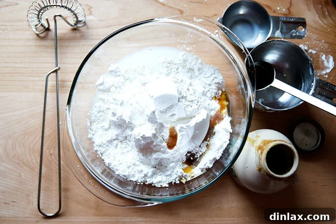 Brown Butter Muscovado Stamped Christmas Cookies 14 The ingredients for the maple glaze in a bowl aside measuring cups, spoons, and a whisk.