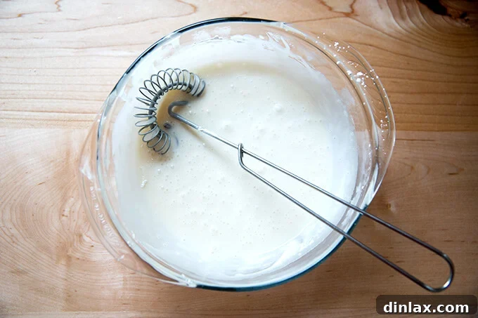 Brown Butter Muscovado Stamped Christmas Cookies 15 A large bowl filled with the maple glaze all whisked up with a whisk inside.