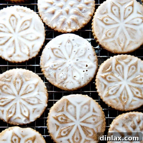 Stamped spiced brown butter muscovado cookies with maple glaze on a cooling rack.