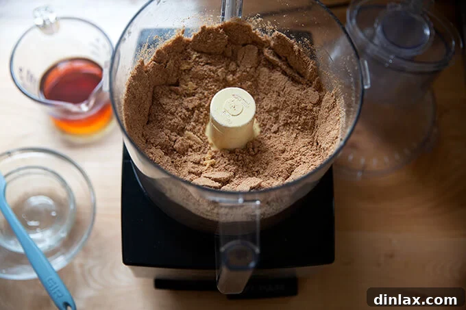 Quick and Boozy Holiday Rum Ball Delight 8 All dry ingredients for rum balls pulsed together in a food processor, forming a cohesive powdery mix.