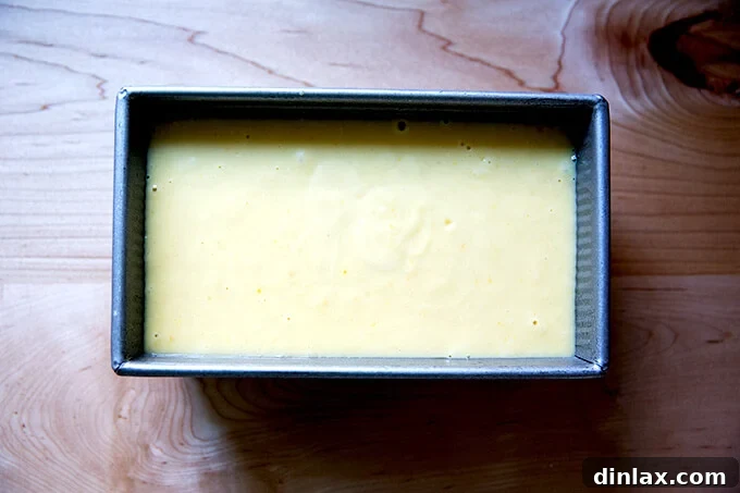 Orange ricotta pound cake batter freshly poured into a 9x5-inch loaf pan, ready for baking.