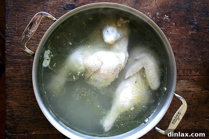 Liquid Gold Chicken Stock 3 Chicken pieces and vegetables covered with water in a large stockpot