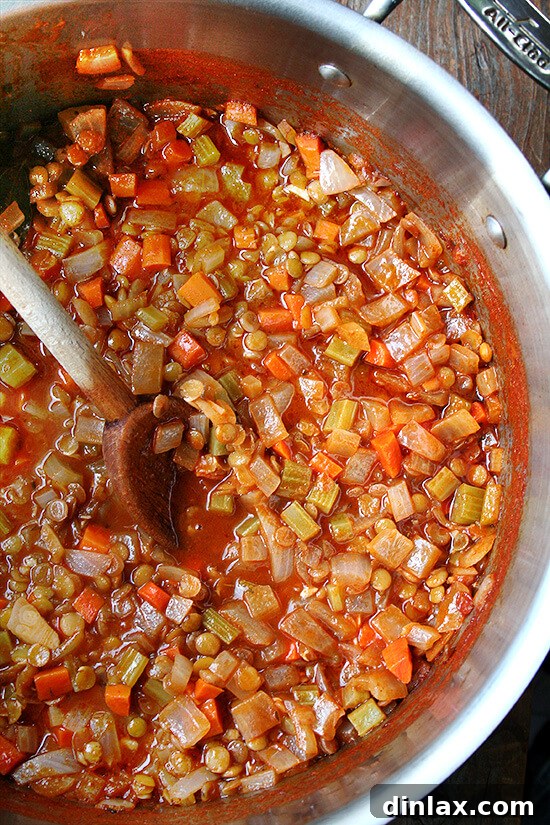 Close-up of a rustic, homemade mini bread loaf, perfectly golden brown and inviting. This crusty bread is ideal for serving alongside a warm bowl of lentil soup. alexandracooks.com