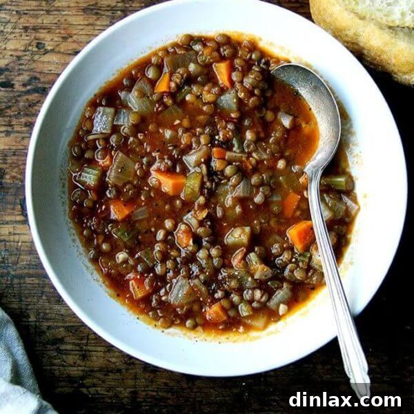 A vibrant bowl of vegan lentil soup, garnished with fresh cracked black pepper and a drizzle of olive oil, ready to be served. Ideal for healthy, comforting winter meals. alexandracooks.com