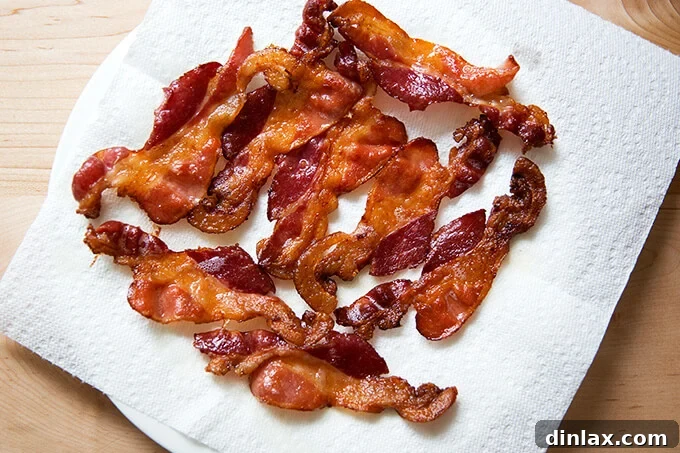 Close-up of freshly cooked, crispy oven-baked bacon on a sheet pan