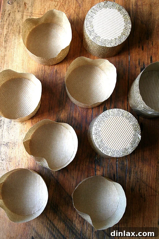 liners A collection of flat-bottomed panettone-style muffin liners arranged neatly on a wooden table, waiting to be filled with delicious batter, emphasizing their unique shape and readiness.