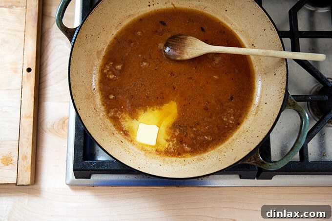 A simple pan sauce being made in a skillet with chicken drippings, butter, and lemon.