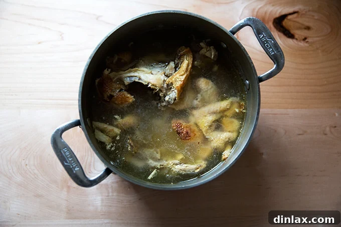 A pot of homemade chicken stock simmering gently on the stovetop.
