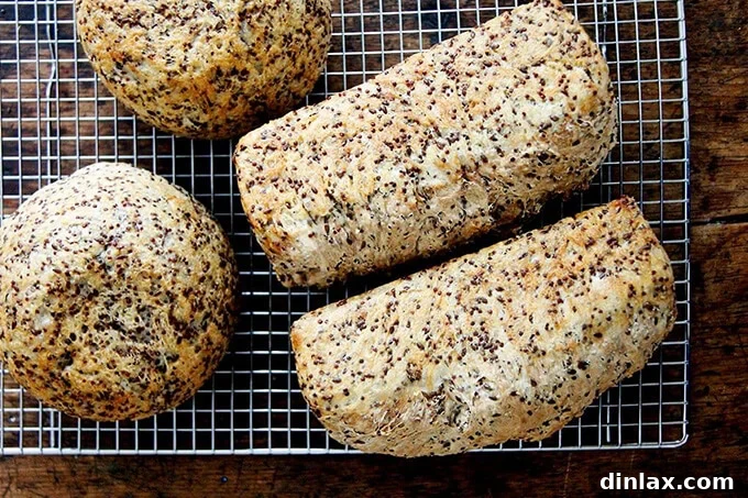 A hearty loaf of Quinoa Flax Toasting Bread, sliced to reveal a dense, seeded interior.