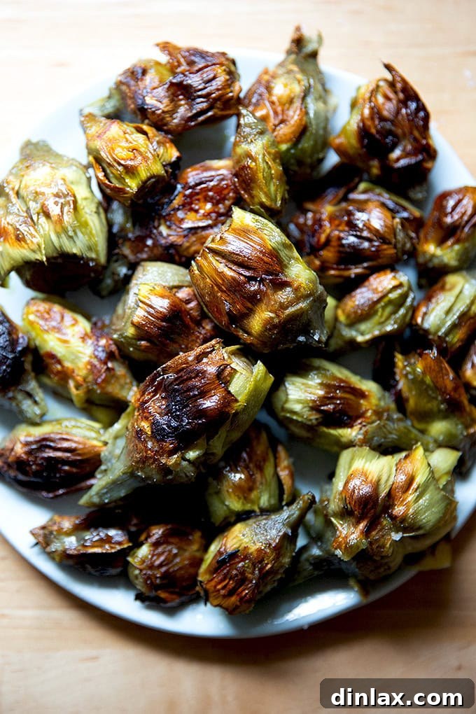 A plate of crispy baby artichokes, garnished with fresh herbs and lemon wedges, ready to be served.