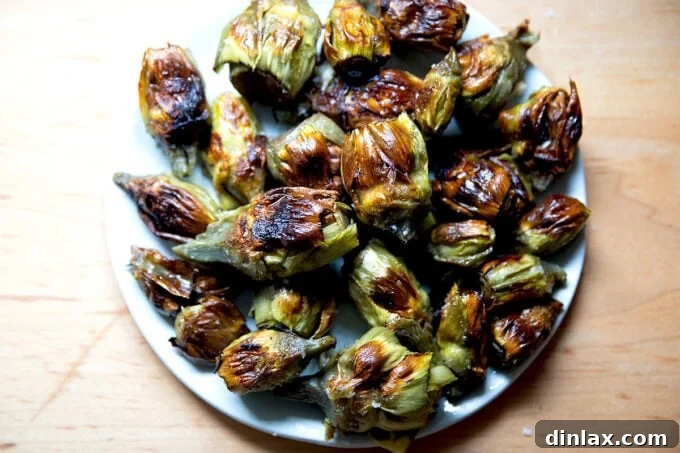 A beautifully arranged plate of crispy baby artichokes, lightly salted, showcasing their golden-brown exterior.