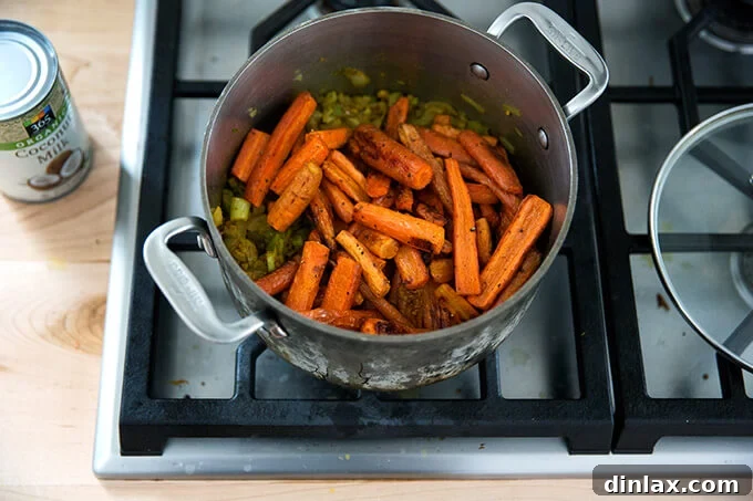 Curried Carrot Ginger Coconut Bliss 12 Adding the roasted carrots to the pot with the aromatic base for the vegan carrot-ginger soup, uniting all the flavors.