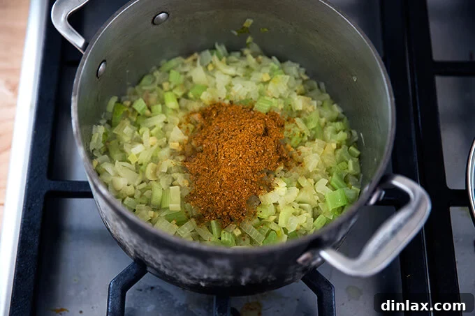Curried Carrot Ginger Coconut Bliss 10 Adding fragrant spices to the softened aromatic vegetables in the pot for the vegan carrot-ginger soup.