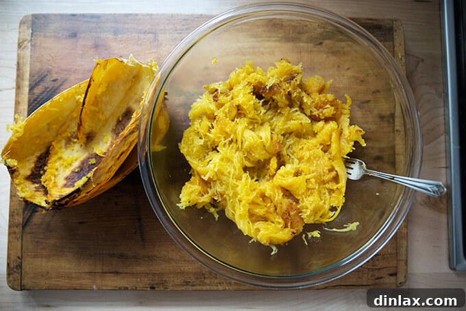 A fork gently shredding the cooked flesh of a spaghetti squash into pasta-like strands.