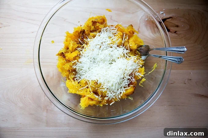 Finely grated Pecorino Romano cheese being added to the spaghetti squash strands, ready for tossing.