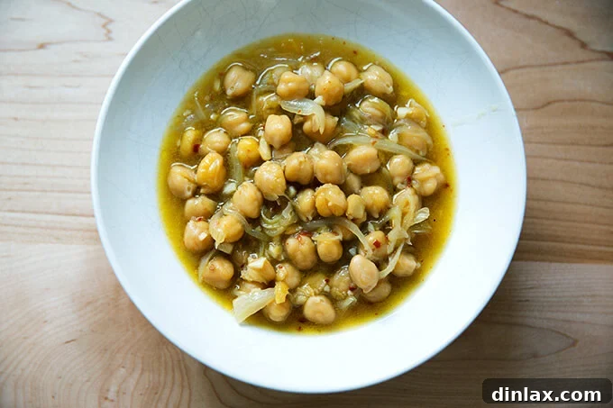 A serving bowl filled with the brothy, stewy, and spicy chickpeas, ready for toppings.