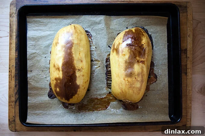 A roasted spaghetti squash half, fresh out of the oven, showing its golden-brown edges.