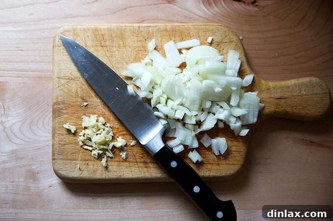 Effortless Instant Pot One Pot Pasta and Meat Sauce 4 Finely minced garlic and diced onions neatly arranged on a wooden cutting board, ready for cooking.
