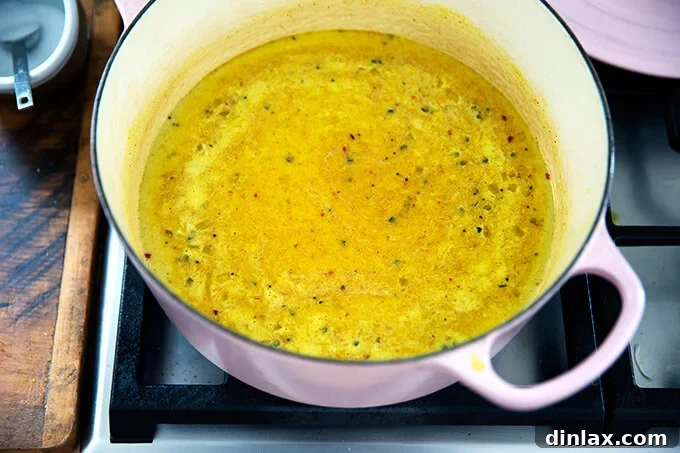 Creamy Coconut Kale Lentil Curry 8 The curried lentil mixture, rich with coconut milk and spices, gently simmering in a Dutch oven on the stovetop, its flavors deepening.
