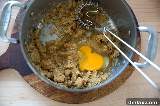 Adding eggs one at a time to the butter and sugar mixture
