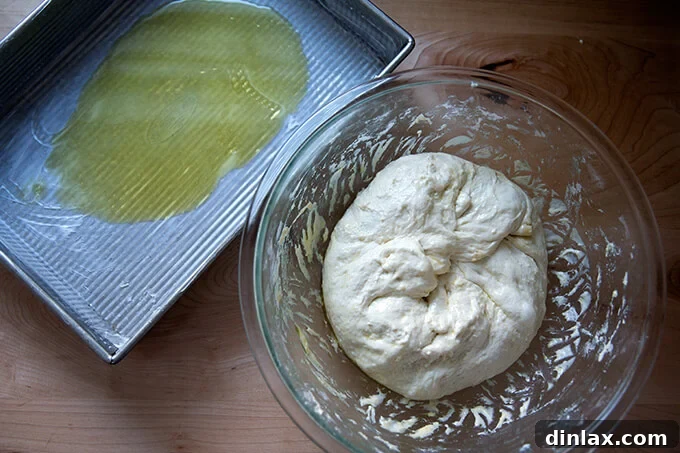 The Easiest Sourdough Focaccia: Perfect for Beginners 17 Deflating sourdough focaccia dough by folding it into the center after 18 hours of rising