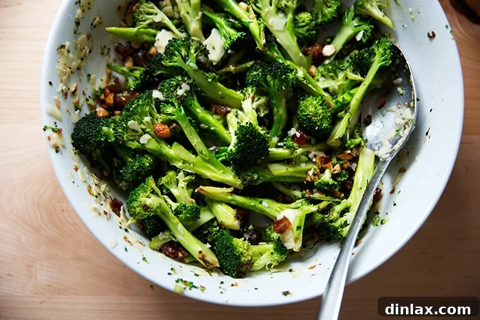 Finished Charred Broccoli Salad with dates, almonds, and cheddar in a serving bowl.