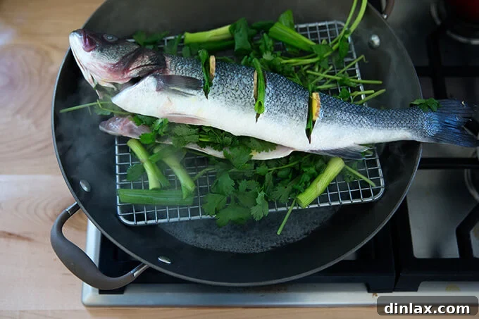 Ginger-Scallion Infused Steamed Whole Fish 11 The Branzino being gently lowered into the wok for steaming.