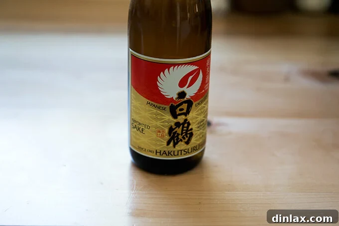 Ginger-Scallion Infused Steamed Whole Fish 12 Sake being poured over the Branzino before steaming, adding a subtle flavor.