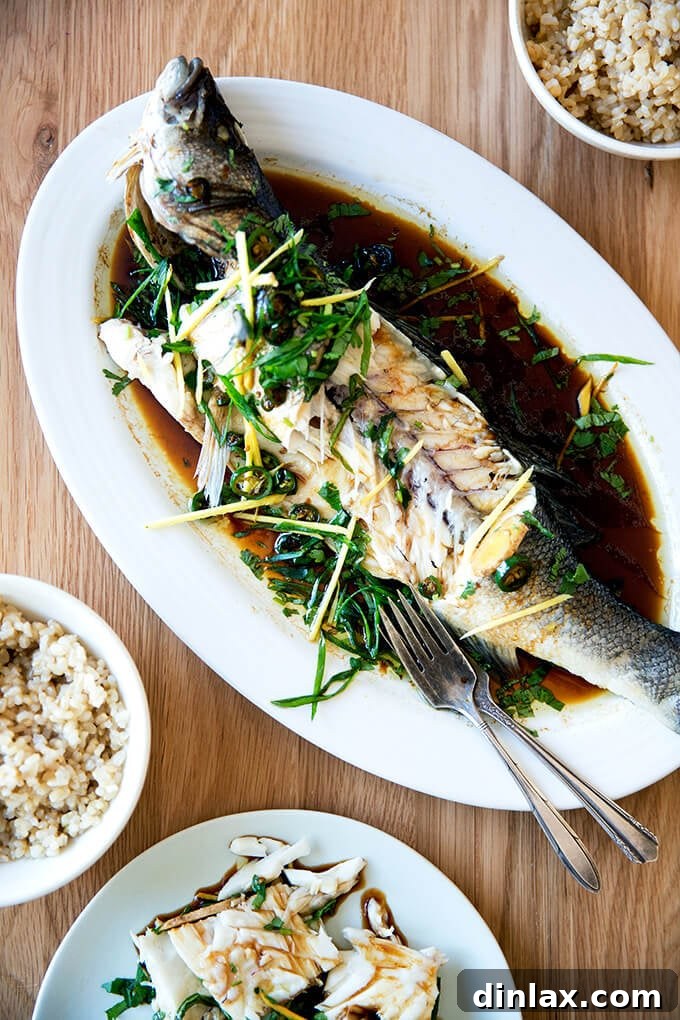 Ginger-Scallion Infused Steamed Whole Fish 18 A stunning presentation of Chinese-style whole Branzino, steamed to perfection with fresh ginger, scallions, cilantro, and a delectable soy-sesame sauce, ready to be served.