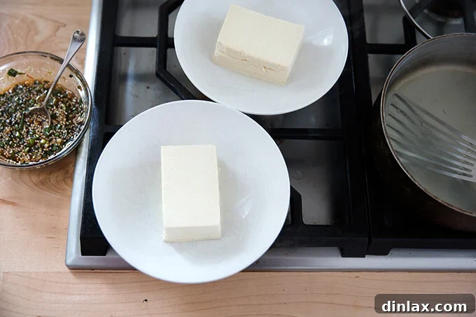 Velvety Tofu with a Garlic Kick 7 Two bowls, each containing a perfectly warmed and halved block of tofu.