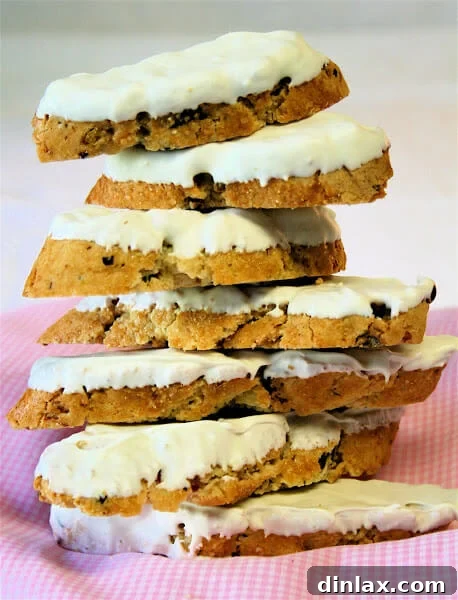 A stack of pistachio-cranberry biscotti dipped in white chocolate, a festive and flavorful variation.