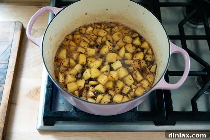 Versatile Apple Chutney Brightened with Ginger and Lemon 6 The apple chutney ingredients, simmering gently in a large pot on the stovetop, slowly reducing and thickening as the flavors meld together.