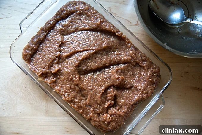 Seasoned apple-date purée in a baking pan, ready for roasting
