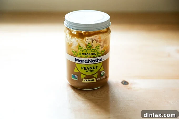 A jar of creamy Maranatha peanut butter on a countertop, ready for use in the dressing.