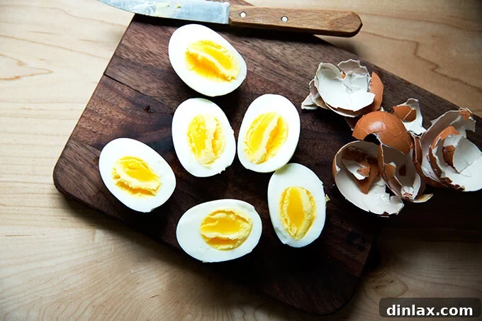 Three perfect Instant Pot hard-boiled eggs, beautifully peeled and halved, showcasing their creamy, vibrant yolks.