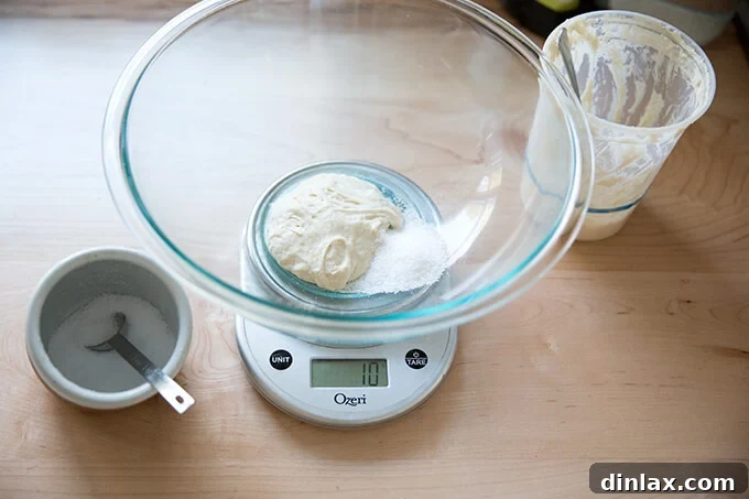 Adding 10 grams of kosher salt to the starter and water mixture.